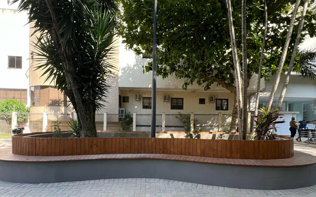 Banco curvo de madeira e paginação de piso na praça de Itapema